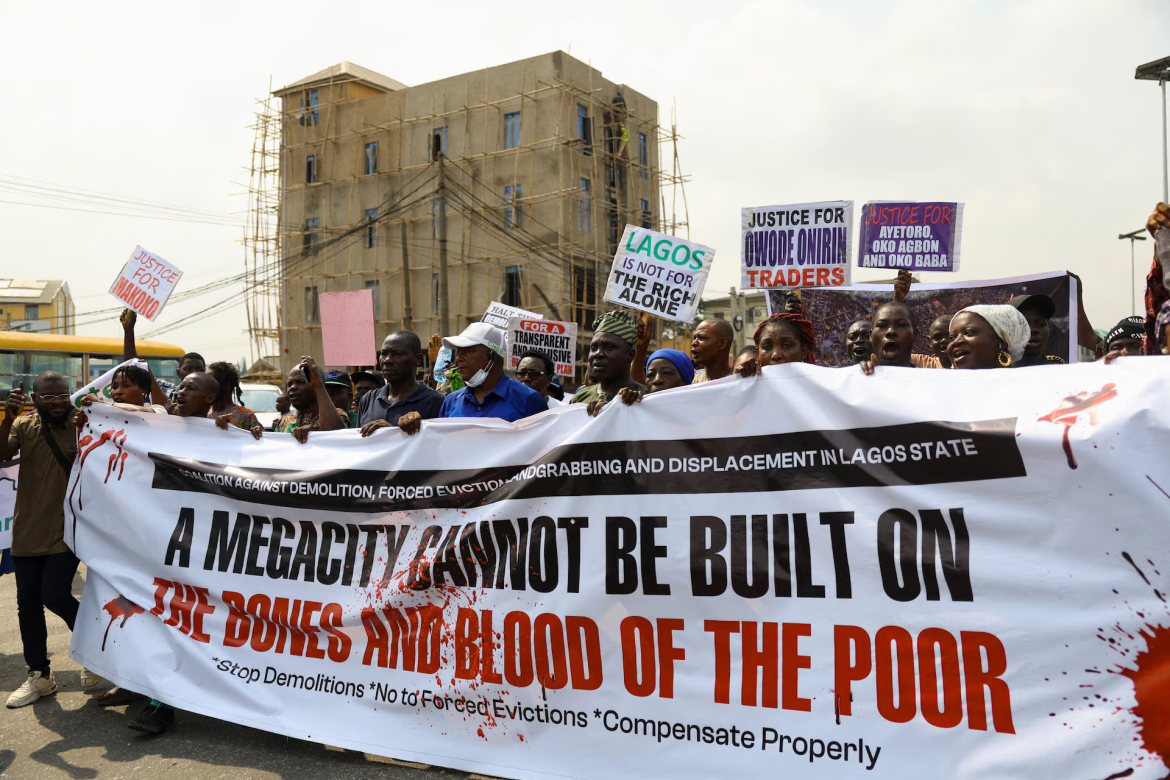 Makoko residents and activists protest ongoing waterfront demolitions in Lagos, carrying placards against forced evictions and displacement.